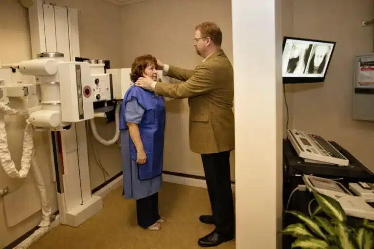 A patient at Bellevue Chiropractic undergoing a videofluoroscopy scan with Dr. John Wisman as the C-arm captures real-time spinal motion