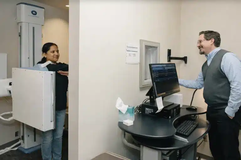 Dr. David Mayes taking Spinal X-rays for the patient to diagnose their root cause, patient smiling while getting their x-rays at Bellevue Chiropractic