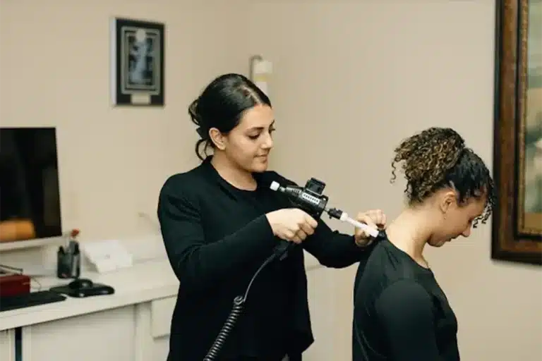 Dr. Diba Naweed performing a precision, non-manual adjustment using the ArthroStim instrument at Bellevue Chiropractic.